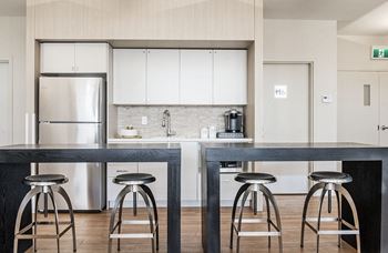 a kitchen with a long counter and three stools